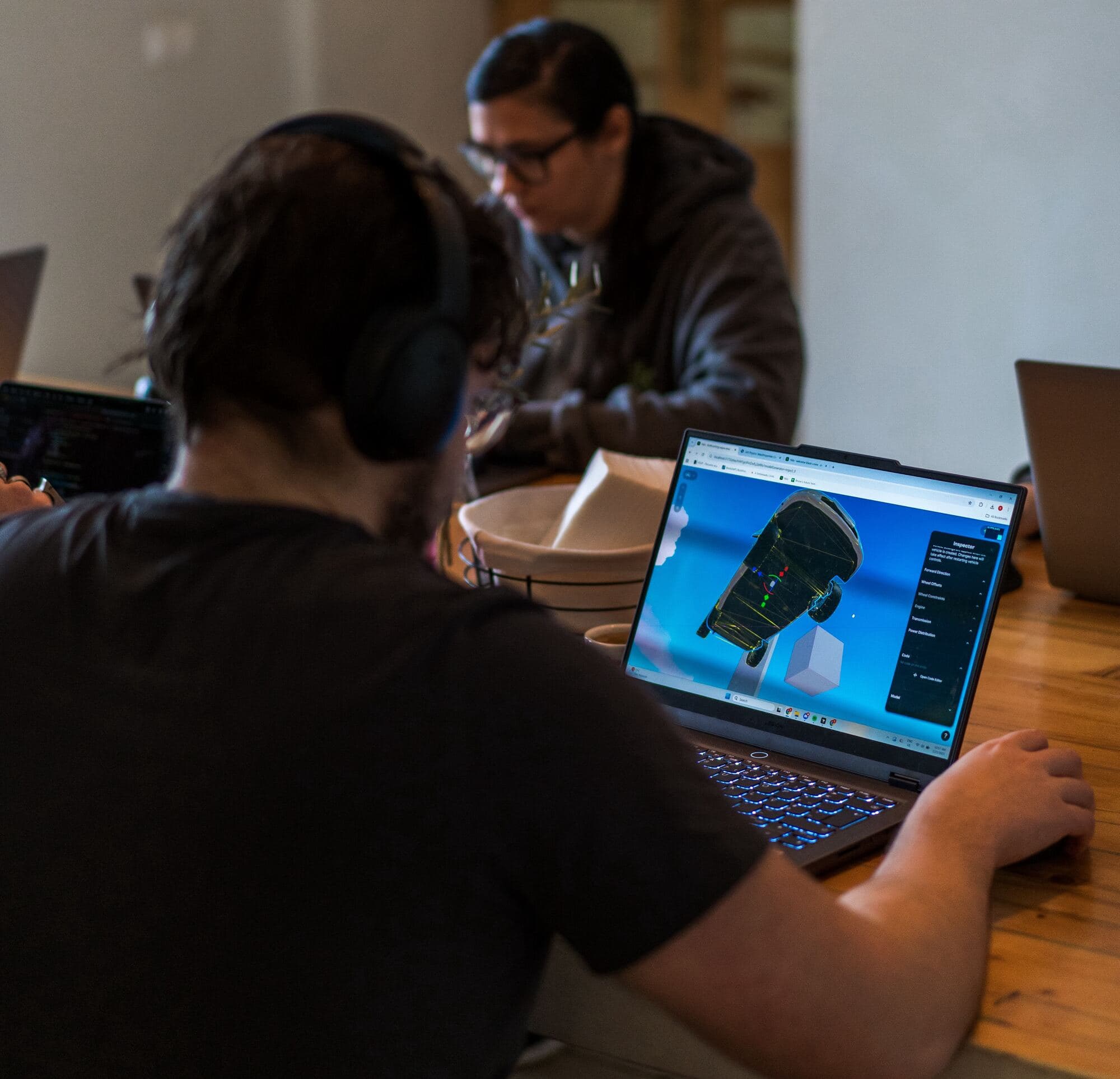 Nilo teammates heads-down during Builder Week, one prototyping a 3D vehicle in the Nilo editor.